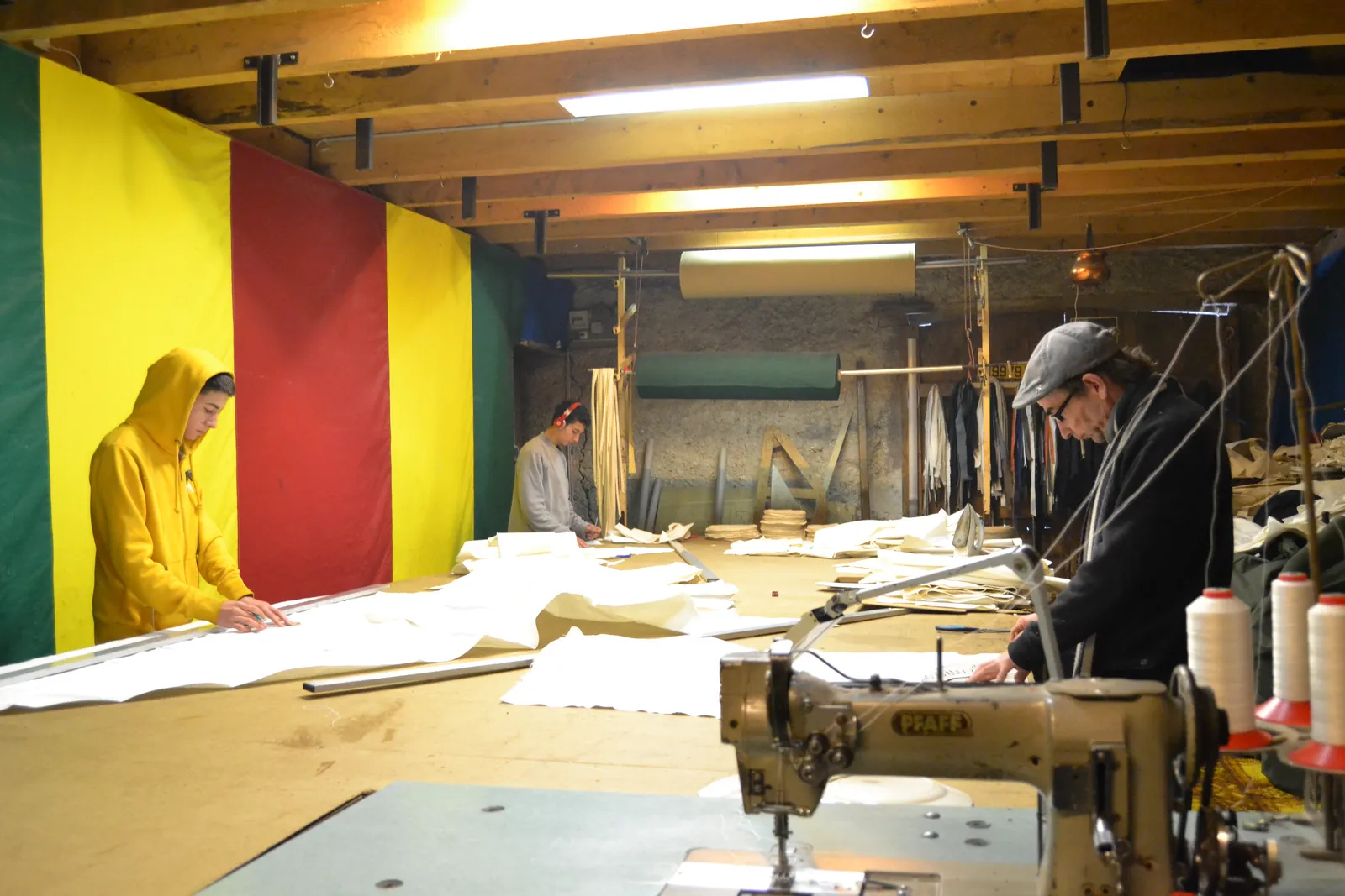 L'atelier de couture : tables de coupe, toiles en cours et machines industrielles